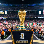 Football Trophy On Stadium Podium Scaled with crowd background, ideal for sports events, transparent background PNG.